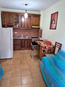a kitchen with a white refrigerator and a table with a table at Holiday Apartment 70meters from the sea in (( Stan i Ri ))