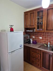 a kitchen with a white refrigerator and wooden cabinets at Holiday Apartment 70meters from the sea in (( Stan i Ri )) +3 photos