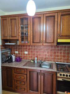 a kitchen with wooden cabinets and a sink at Holiday Apartment 70meters from the sea in (( Stan i Ri ))