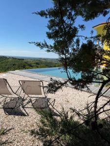 two chairs sitting on a beach with a swimming pool at La Cubanita in Kojsko