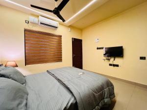 a bedroom with a bed and a flat screen tv at SJ Homes in Karukachal