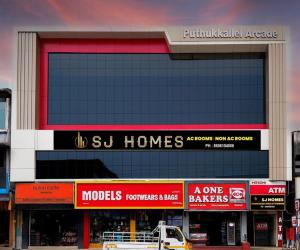 a building with many signs on the side of it at SJ Homes in Karukachal