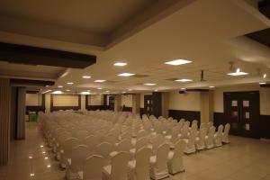 an empty room with white chairs in a building at PLA RESIDENCY Trichy near Rockfort Temple in Tiruchirappalli