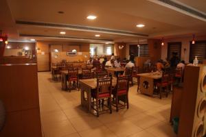 a dining room with people sitting at tables in a restaurant at PLA RESIDENCY Trichy near Rockfort Temple in Tiruchirappalli
