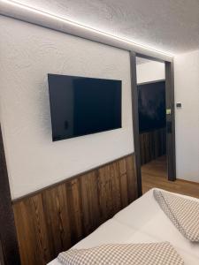 a bedroom with a flat screen tv on a wall at Waldhaus Talblick in Biberwier