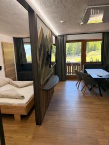 a room with a bed and a table and chairs at Waldhaus Talblick in Biberwier