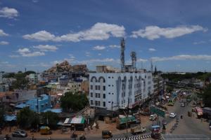 a city with a white building and a busy street at PLA RESIDENCY Trichy near Rockfort Temple in Tiruchirappalli