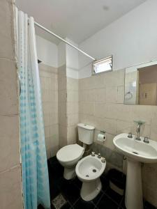 a bathroom with a white toilet and a sink at Hotel Estrella Andina in San Juan +62 photos