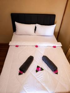a bed with two towels and flowers on it at El-Mindri Bungalow dan Resto in Gili Gede
