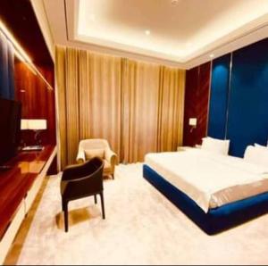 a bedroom with a bed and a chair and a television at Chorchaman Hills in Patkunob