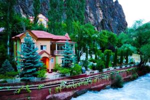a house on the side of a river next to a mountain at Chorchaman Hills in Patkunob