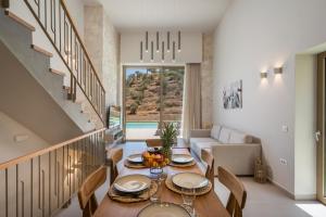 a dining room with a table and a couch at La Divina Luxury Villas with Heated Pool in Daratso