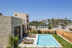 a villa with a swimming pool and lounge chairs at La Divina Luxury Villas with Heated Pool in Daratso