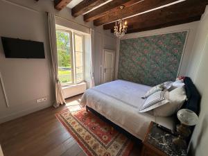 a bedroom with a bed and a large window at La Brosse Estate - Chateau de la Brosse in Lureuil