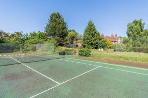a tennis court with a net on top of it at Woods Meadow Glamping in West Malling