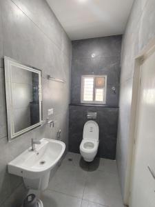 a bathroom with a white toilet and a sink at Sri Padmavati Pleasants in Palni +29 photos
