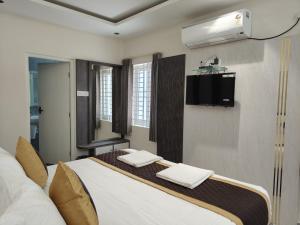 a bedroom with a bed with two towels on it at Sri Padmavati Pleasants in Palni