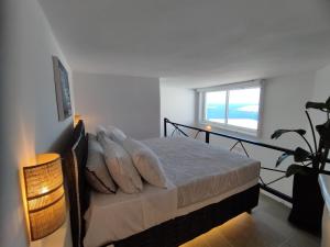 a bedroom with a bed with pillows and a window at Caldera Serenity - Small Luxury Villas in Imerovigli