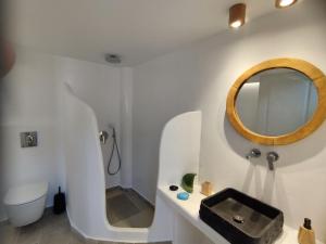a white bathroom with a sink and a mirror at Caldera Serenity - Small Luxury Villas in Imerovigli +22 photos