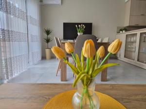 a vase of yellow tulips on a table in a living room at Lawendowa Home in Milicz