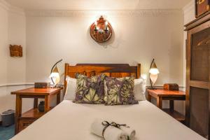 a bedroom with a bed and two nightstand tables at Villa Simonne in Johannesburg