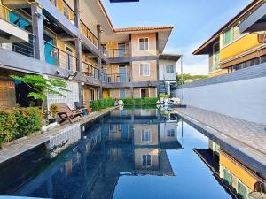 a swimming pool in front of a building at Ora House in San Kamphaeng