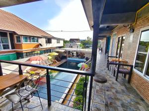 a balcony with a pool and tables and chairs at Ora House in San Kamphaeng +31 photos