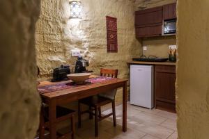 a kitchen with a wooden table and a white refrigerator at Sirocave barlang apartmanok in Sirok