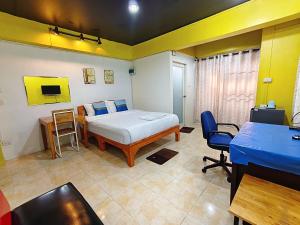 a bedroom with a bed and a desk and a table at Ora House in San Kamphaeng