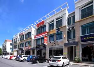 a large building with cars parked in a parking lot at Hotel O Lm Residence in Miri