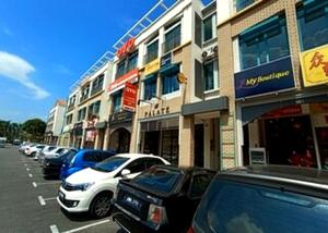 a row of cars parked in a parking lot next to buildings at Hotel O Lm Residence in Miri