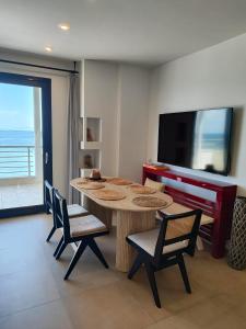 a dining room with a table and chairs and a television at Vista mare by Oikies Rentals in Neoi Epivates