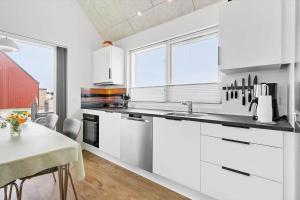 a kitchen with white cabinets and a table in it at 945-Hvide-Sande-Langsand-163 in Hvide Sande +25 photos