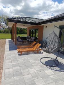 a patio with two wooden benches and a swing at Villa Verde House by the River Sturba in Livno