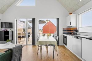 a kitchen and dining room with a table and chairs at 945-Hvide-Sande-Langsand-163 in Hvide Sande