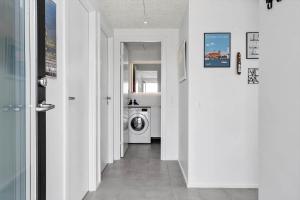 a hallway with a washing machine in a white room at 945-Hvide-Sande-Langsand-163 in Hvide Sande