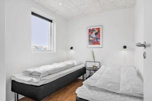 two beds in a white room with a window at 945-Hvide-Sande-Langsand-163 in Hvide Sande