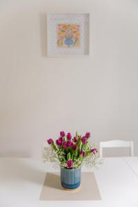 a vase filled with purple flowers on a table at La Stazione Formia in Formia