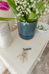 a table with a vase of flowers and a pair of keys at La Stazione Formia in Formia