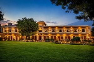 a large house with a large lawn in front of it at Kadamb Kuteer Hotel and Resort in Chhatikara