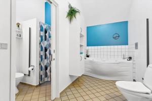 a bathroom with a tub and a toilet and a sink at 704-Hvide-Sande-Slusen-4 in Hvide Sande +36 photos