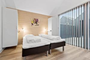 a bed in a room with a large window at 704-Hvide-Sande-Slusen-4 in Hvide Sande