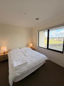 a bedroom with a bed and a large window at Shared House in Melbourne in Bundoora
