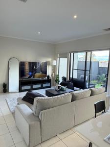 a living room with a large couch and a table at Shared House in Melbourne in Bundoora