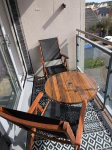 a table and chairs on a balcony with a table and a chair at Neptune 27 in Swansea