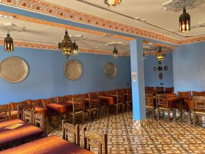 a restaurant with wooden tables and chairs in a room at Riad Dar Fatima in Merzouga