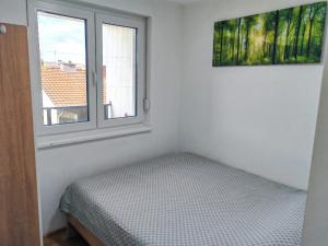 a bedroom with a bed next to a window at Apartman Max in Modriča