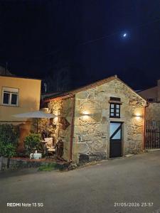 a stone building with a barn with a white door at "la Casita" in Boiro