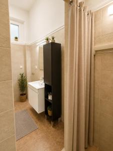 a bathroom with a sink and a black shower curtain at Asana by Agora Flats in Thessaloniki +30 photos