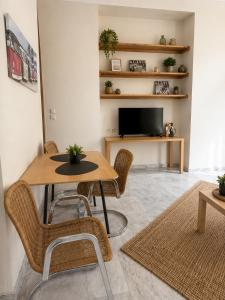 a living room with a table and chairs and a tv at Asana by Agora Flats in Thessaloniki